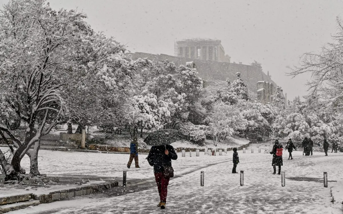 People walk through snow-covered walking zone near the Acropolis in Athens during heavy snowfall  on Jan. 24, 2022. (Louisa Gouliamaki/AFP via Getty Images)