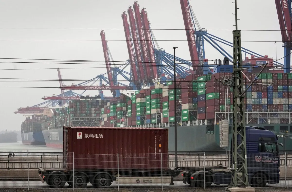 A truck drives in front of huge container ships at the port in Hamburg, Germany, on Jan. 19, 2022. (Martin Meissner/AP Photo)