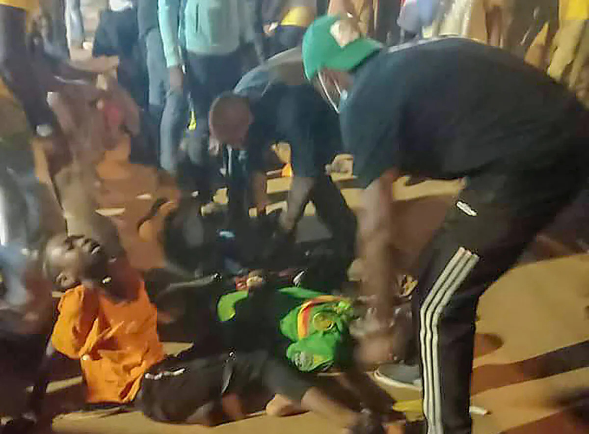 People assist victims of a stampede outside a stadium hosting an African Cup of Nations soccer game in Yaounde, Cameroon, on Jan. 24, 2022. (Thierry Noukeu/AP Photo)