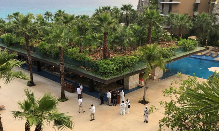 Forensic technicians and hotel employees stand near a scene where three Canadian citizens were injured by gunshots at Hotel Xcaret, in Playa del Carmen, Mexico Jan. 21, 2022. (Reuters/Stringer)