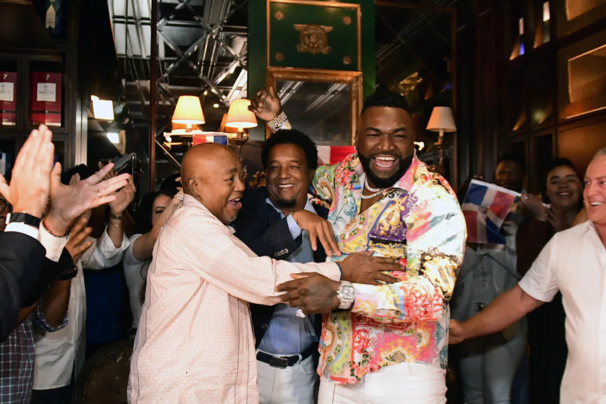 Former Boston Red Sox player David Ortiz celebrates his election to the hall of fame with his father Leo Ortiz, left, MLB Hall of Fame player Pedro Martinez , center, and Fernando Cuzza, right, moments after receiving the news in Santo Domingo, Dominican Republic, on Jan. 25, 2022. (AP Photo/Manolito Jimenez)