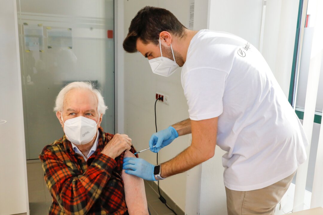 Kurt Switil, left, receives a Pfizer in Vienna, on April 10, 2021. (Lisa Leutner/AP Photo)