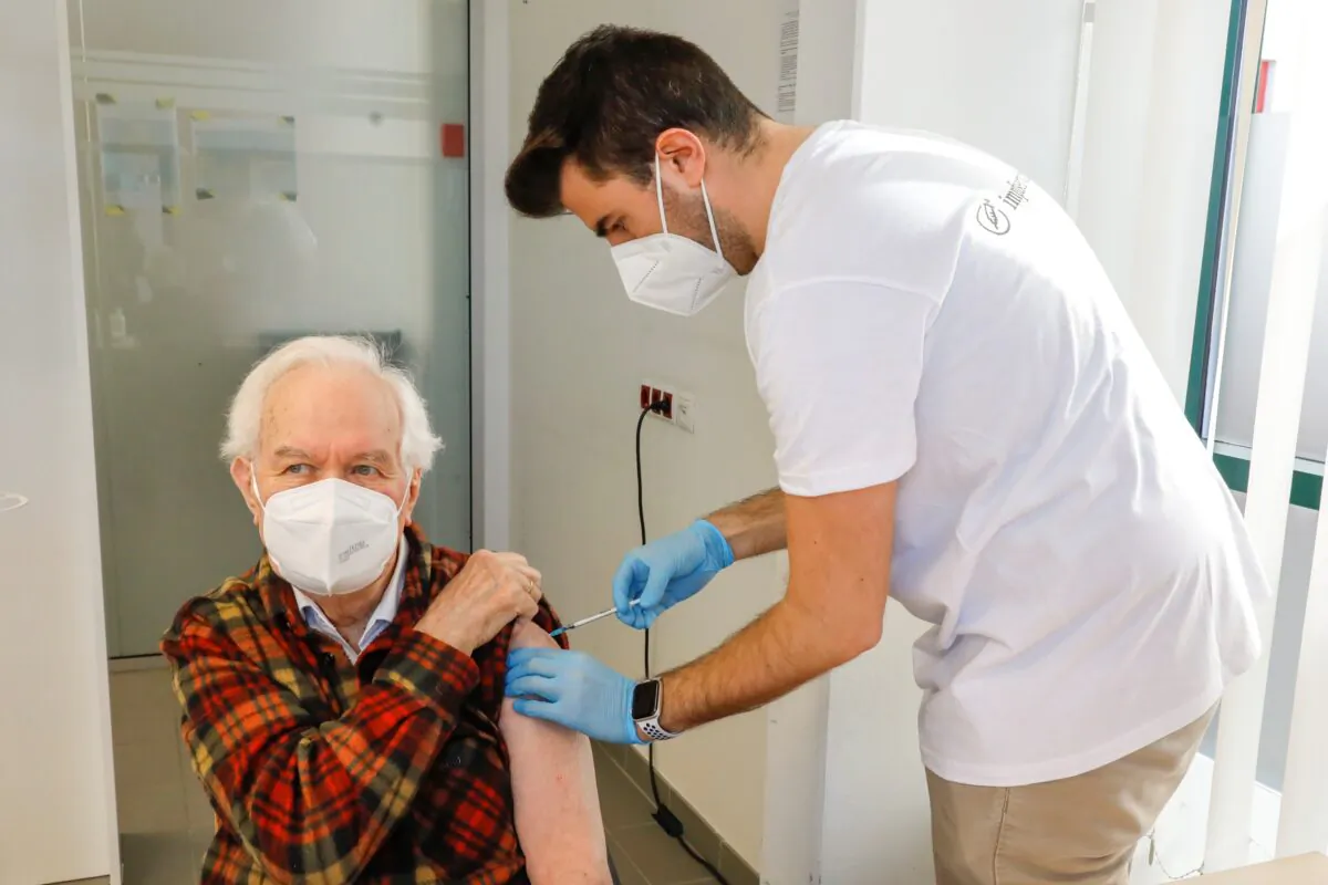 Kurt Switil, left, receives a Pfizer in Vienna, on April 10, 2021. (Lisa Leutner/AP Photo)