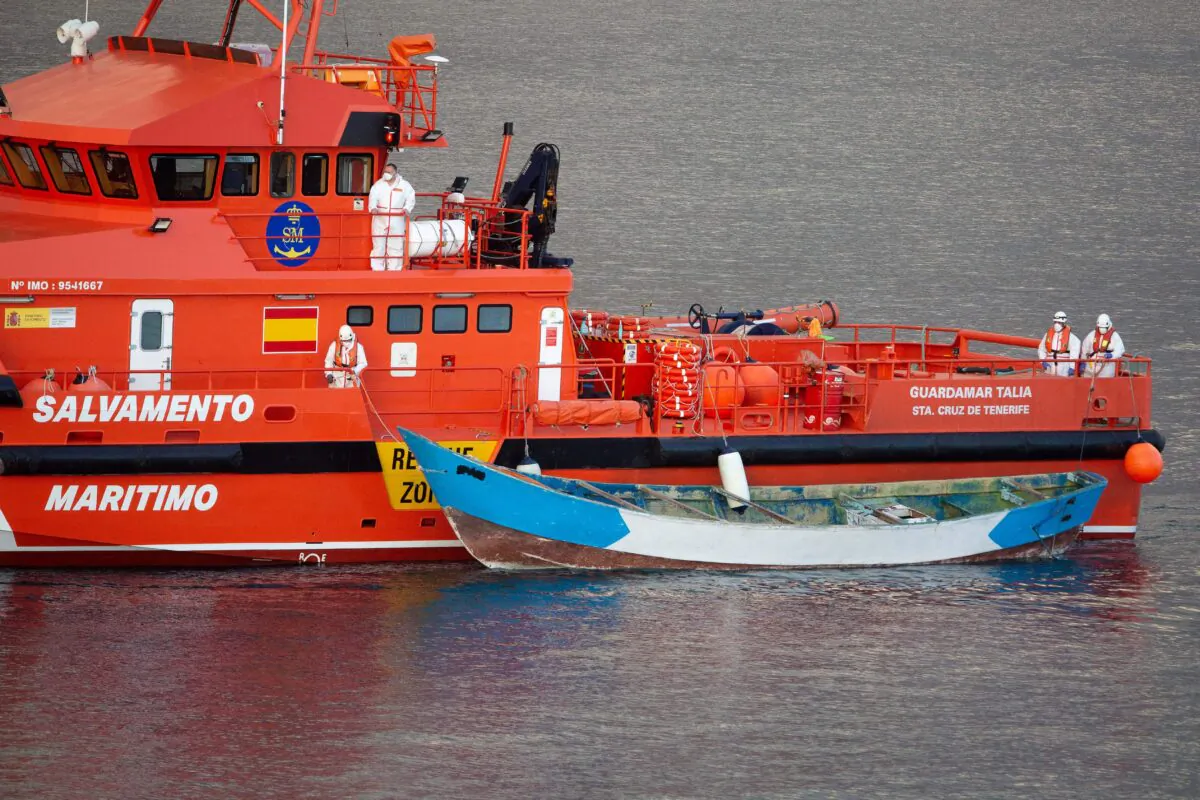 A Spanish maritime rescue vessel arrives with a wooden boat in tow at the port of Los Cristianos on the island of Tenerife, after it was found drifting off the coast of the Spanish Canary Islands, on April 28, 2021. (Desiree Martin/AFP via Getty Images)