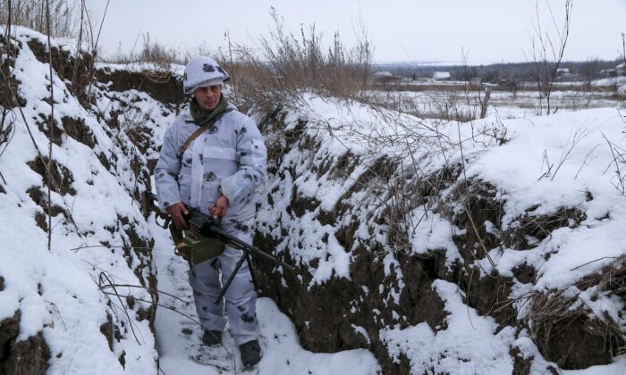 A serviceman stands holding his machine-gun in a trench on the territory controlled by pro-Russian militants at frontline with Ukrainian government forces in Slavyanoserbsk, Luhansk region, eastern Ukraine, on Jan. 25, 2022. (Alexei Alexandrov/AP Photo)
