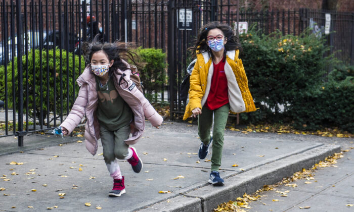 Students wearing masks leave the New Explorations into Science, Technology and Math (NEST+m) school in the Lower East Side neighborhood of Manhattan, N.Y., on Dec. 21, 2021. (Brittainy Newman/AP Photo)