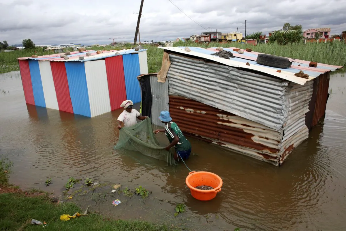 People use a net to catch fish around their flooded dwelling in Antananarivo, Madagascar, on Jan. 24, 2022. (Alexander Joe/AP Photo)