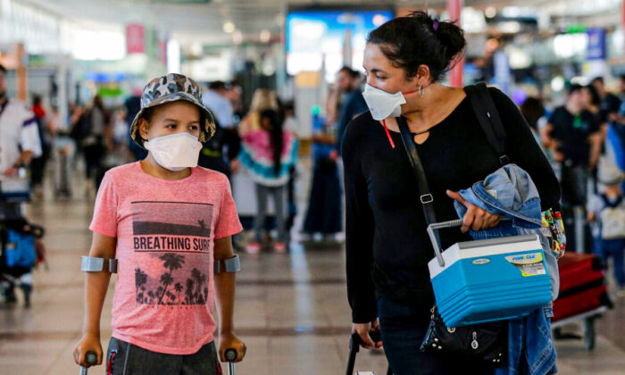 Passengers walk with protective masks at the Arturo Merino Benitez International Airport, in Santiago, on Mar. 3, 2020. (Javier Torres/AFP via Getty Images)