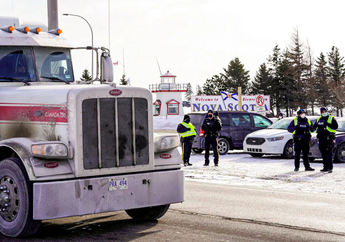 A truck passes by the Canadian truck convoy/protest along the New Brunswick/Nova Scotia border in Fort Lawrence, Nova Scotia, Canada, on Jan. 23, 2022. (John Morris/Reuters)