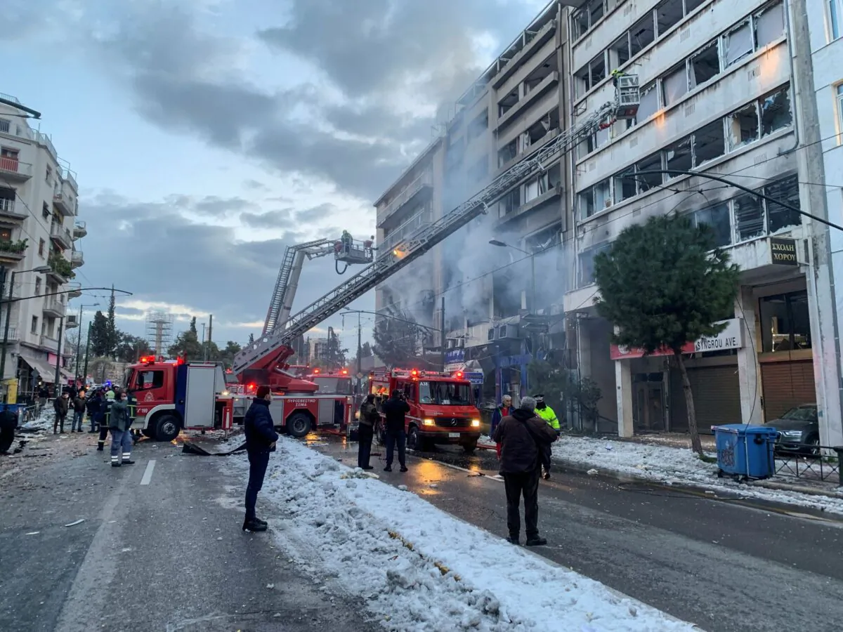 Firefighters use aerial ladders to look for anyone possibly trapped inside damaged buildings following an explosion in central Athens, Greece, on Jan. 26, 2022. (Derek Gatopoulos/AP Photo)