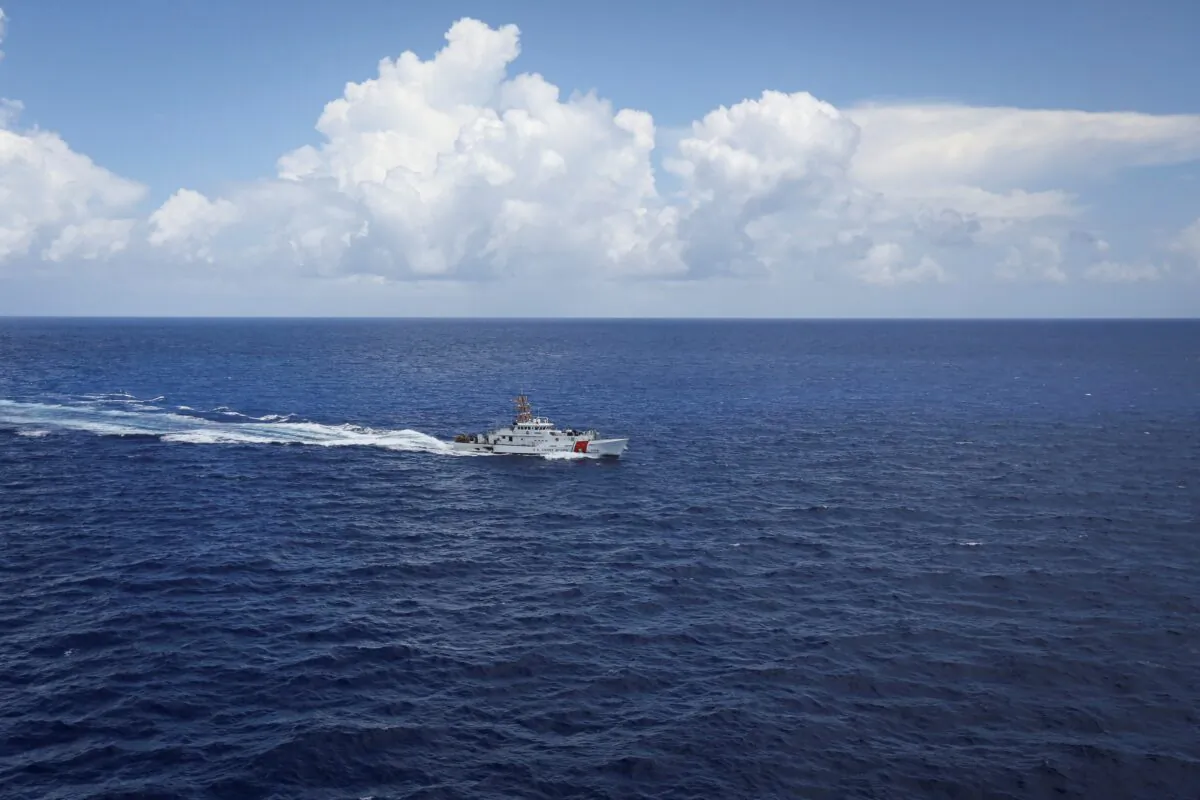 A Coast Guard vessel is seen from the open hatch of an HC-144 Ocean Sentry aircraft during a patrol mission, in the Florida Straits, on July 17, 2021. (Marco Bello/Reuters)
