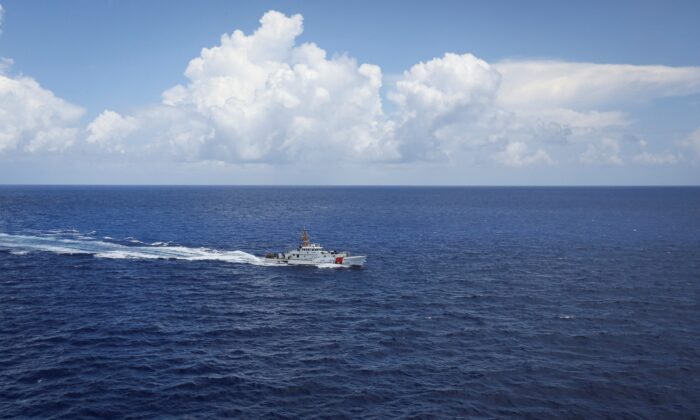 A Coast Guard vessel is seen from the open hatch of an HC-144 Ocean Sentry aircraft during a patrol mission, in the Florida Straits, on July 17, 2021. (Marco Bello/Reuters)