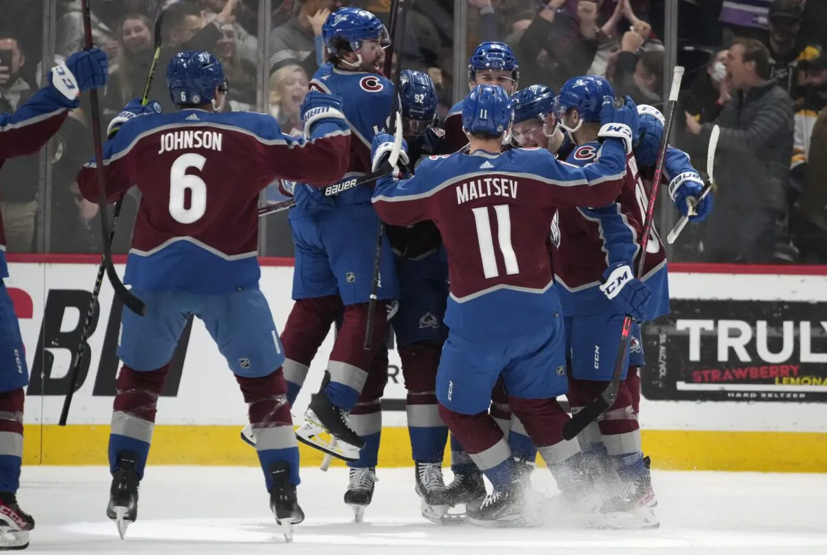 Colorado Avalanche players celebrate with defenseman Cale Makar after his power-play goal in overtime of an NHL hockey game against the Boston Bruins in Denver, on Jan. 26, 2022. (David Zalubowski/AP Photo)