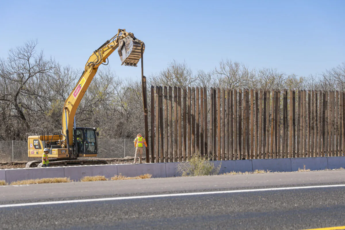 Construction workers place a bollard along the border wall in Eagle Pass, Texas, on Jan. 25, 2022. (Charlotte Cuthbertson/The Epoch Times)