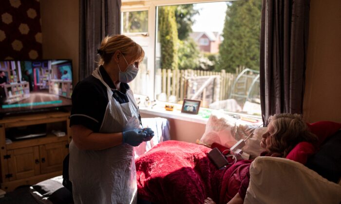 Team leader for housebound vaccinations, Julie Fletcher, prepares to administer a dose of the AstraZeneca/Oxford COVID-19 vaccine to housebound patient, Gillian Marriott, at her home in Hasland, near Chesterfield, central England, on April 14, 2021. (Oli Scarff/AFP via Getty Images)