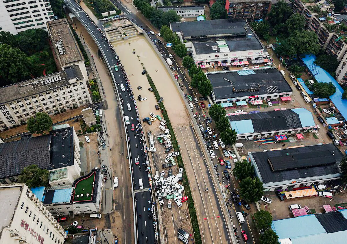 An aerial view shows cars sitting in floodwaters at the entrance of Jingguang Expressway tunnel after heavy rains hit the city of Zhengzhou in China's central Henan province on July 22, 2021. (Noel Celis / AFP) 