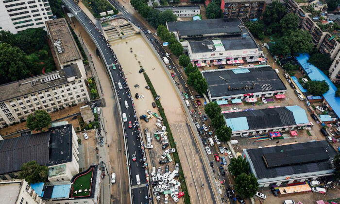 An aerial view shows cars sitting in floodwaters at the entrance of Jingguang Expressway tunnel after heavy rains hit the city of Zhengzhou in China's central Henan province on July 22, 2021. (Noel Celis / AFP) 