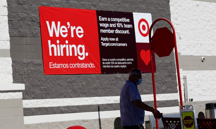 A "We're hiring" sign hangs on the wall of a Target store in Miami, Fla., on Dec. 03, 2021. (Joe Raedle/Getty Images)