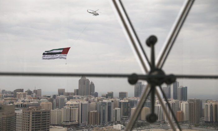 A helicopter flies over the downtown skyline of Abu Dhabi, United Arab Emirates, April 20, 2020. (Christopher Pike/Reuters)