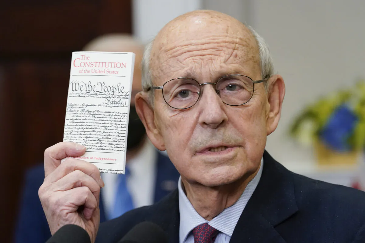 Supreme Court Associate Justice Stephen Breyer holds up a copy of the U.S. Constitution as he announces his retirement in the Roosevelt Room of the White House on Jan. 27, 2022. (Andrew Harnik/AP Photo)