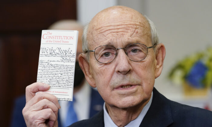 Supreme Court Associate Justice Stephen Breyer holds up a copy of the United States Constitution as he announces his retirement in the Roosevelt Room of the White House in Washington on Jan. 27, 2022. (Andrew Harnik/AP Photo)