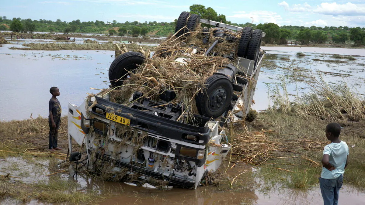 Locals look at a wreck washed away during Tropical Storm Ana on the flooded Shire river, an outlet of Lake Malawi at the village of Thabwa in Chikwawa district, southern Malawi, on Jan. 26, 2022. (Eldson Chagara/Reuters)