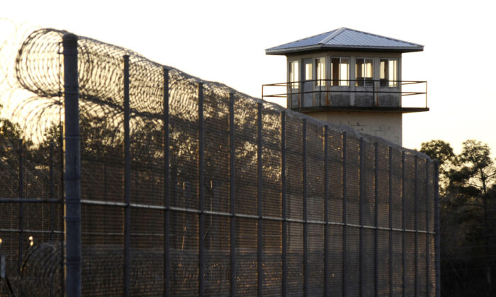 The sun sets behind Holman Prison in Atmore, Ala., on Jan., 27, 2022. (AP Photo/Jay Reeves)