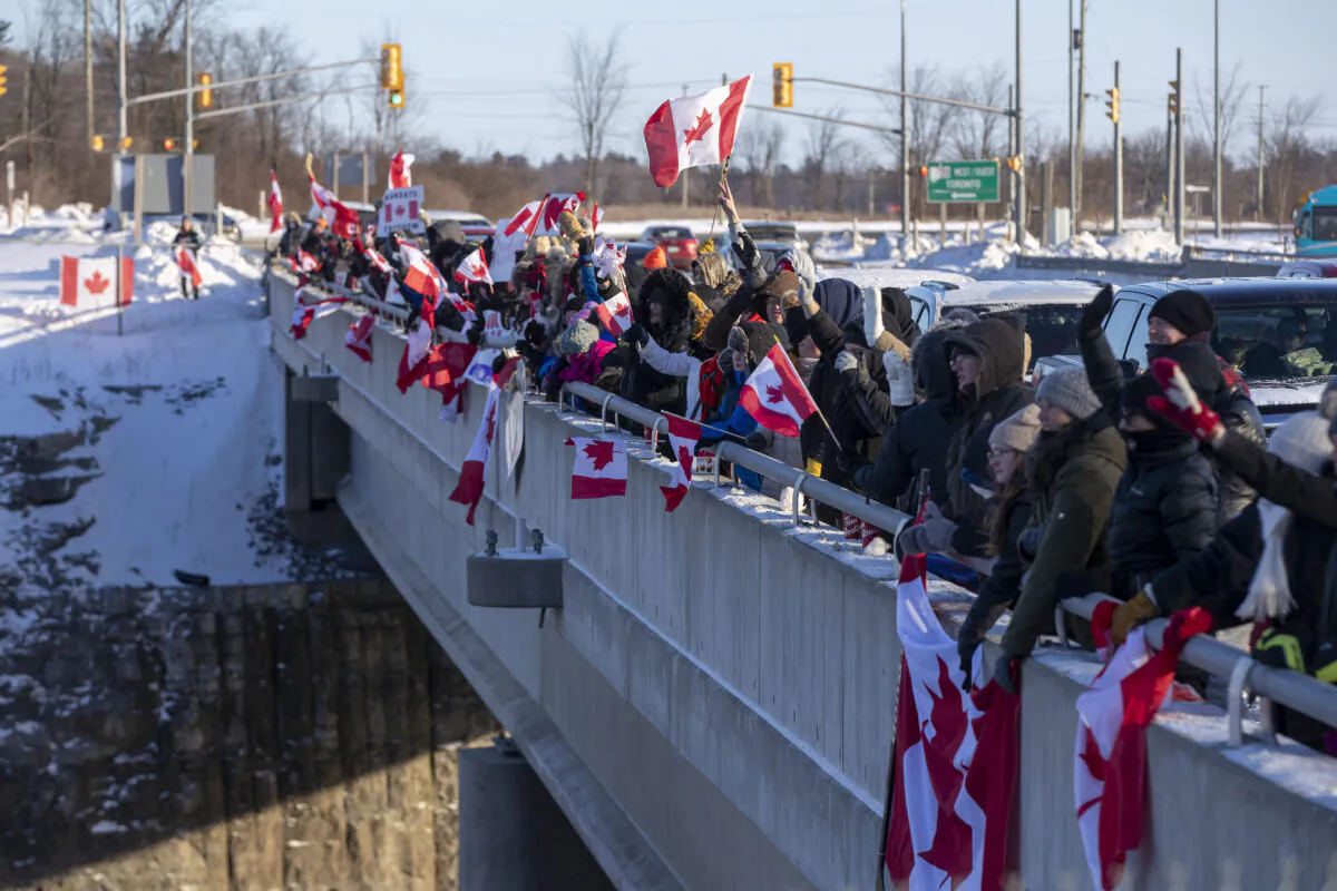 Supporters cheer on truck drivers in the Freedom Convoy headed for Ottawa from an overpass in Kingston, Ont., on Jan. 28, 2022. (The Canadian Press/Lars Hagberg)