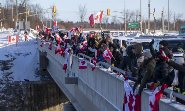 Supporters cheer on truck drivers in the "Freedom Convoy" headed for Ottawa from an overpass in Kingston, Ont., on Jan. 28, 2022. (The Canadian Press/Lars Hagberg)
