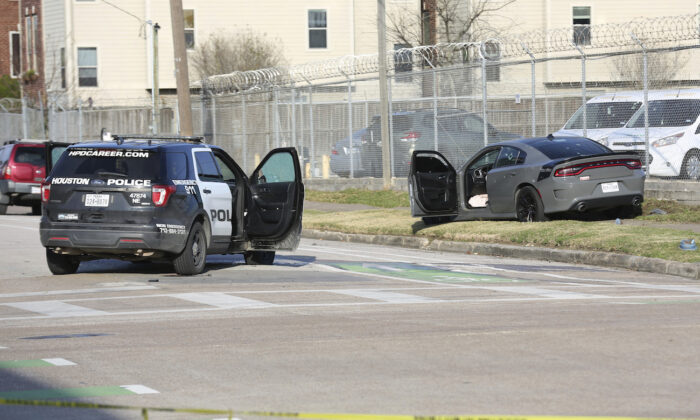 Authorities investigate the scene where three Houston Police officers were reportedly shot in the 2200 block of McGowen St., at the intersection of McGowen Street and Hutchins Street, in Houston, on Jan. 27, 2022. (Jon Shapley/Houston Chronicle via AP)