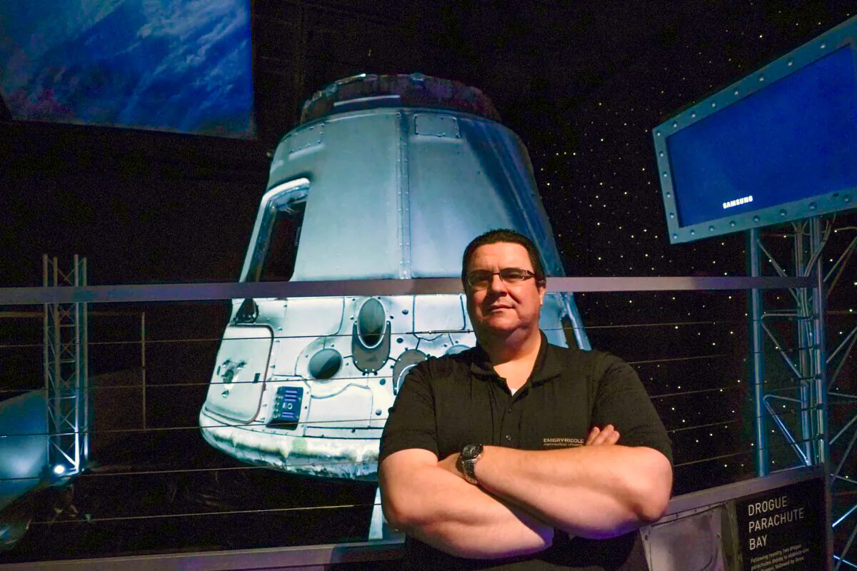 Kyle Hippchen poses for a photo in front of a SpaceX Dragon capsule at the Kennedy Space Center Visitor Complex in Cape Canaveral, Fla., on Jan. 21, 2022. (John Raoux/AP Photo)