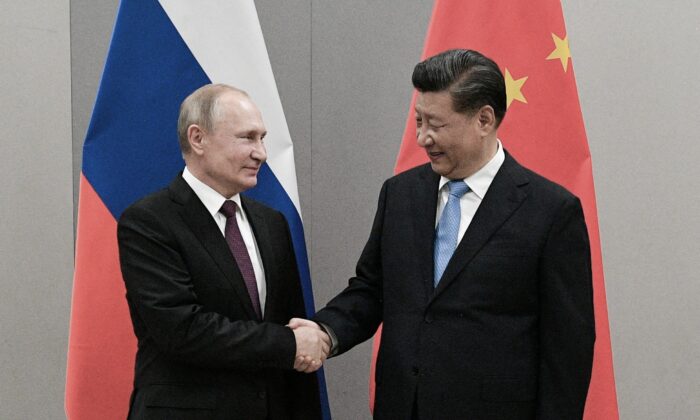 Russian President Vladimir Putin shakes hands with Chinese leader Xi Jinping during their meeting on the sidelines of a BRICS summit, in Brasilia, Brazil, Nov. 13, 2019. (Sputnik/Ramil Sitdikov/Kremlin via Reuters)
