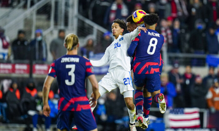 El Salvador’s Enrico Duenas (20) goes up for the ball against United States’ Weston McKennie (8) and Tyler Adams, back,   Walker Zimmerman (3) looks on, during the first half of a FIFA World Cup qualifying soccer match, in Columbus, Ohio, Jan. 27, 2022. (Julio Cortez/AP Photo)