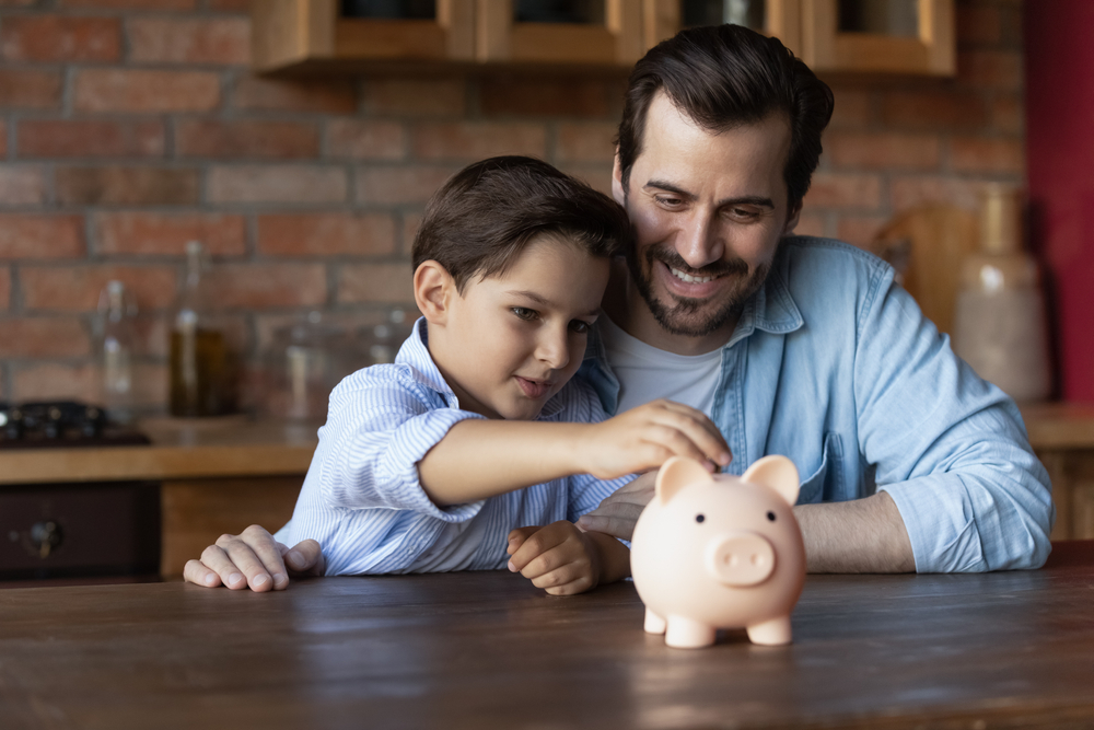The goal is to create knowledge, reward his interest in the subject, and teach him how to handle his finances when he’s an adult. (fizkes/Shutterstock)
