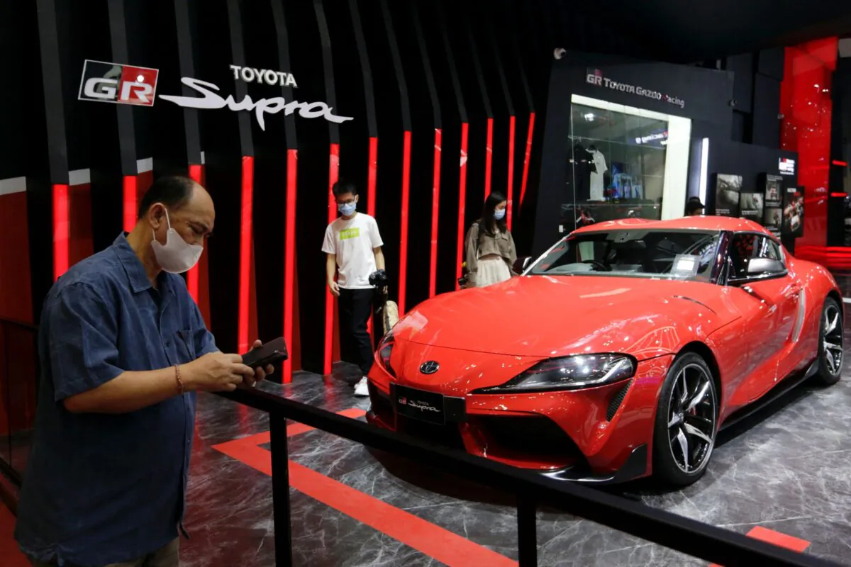 People stand near a Toyota GR Supra at the Indonesia International Auto Show in Tangerang, near Jakarta, Indonesia, on Nov. 12, 2021. (Ajeng Dinar Ulfiana/Reuters)
