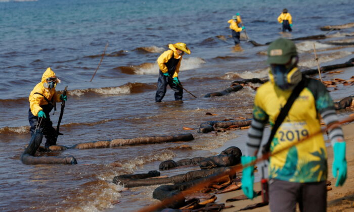 Workers clean oil spills caused by a leak from an undersea pipeline 12.4 miles off Thailand's eastern coast at Mae Ramphueng beach in Rayong province, Thailand, on Jan. 29, 2022. (Soe Zeya Tun/Reuters)