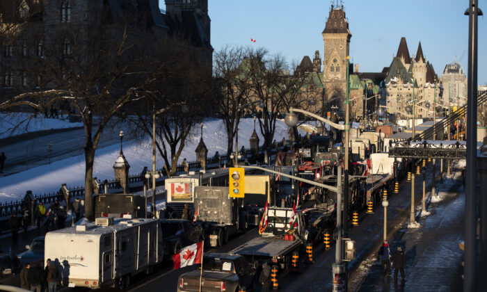Trucks participating in a cross-country convoy  protesting Canada's COVID-19 vaccine mandates, dubbed Freedom Convoy 2022, are parked on Wellington Street in front of Parliament Hill in Ottawa on Jan. 28, 2022. (Justin Tang/The Canadian Press)