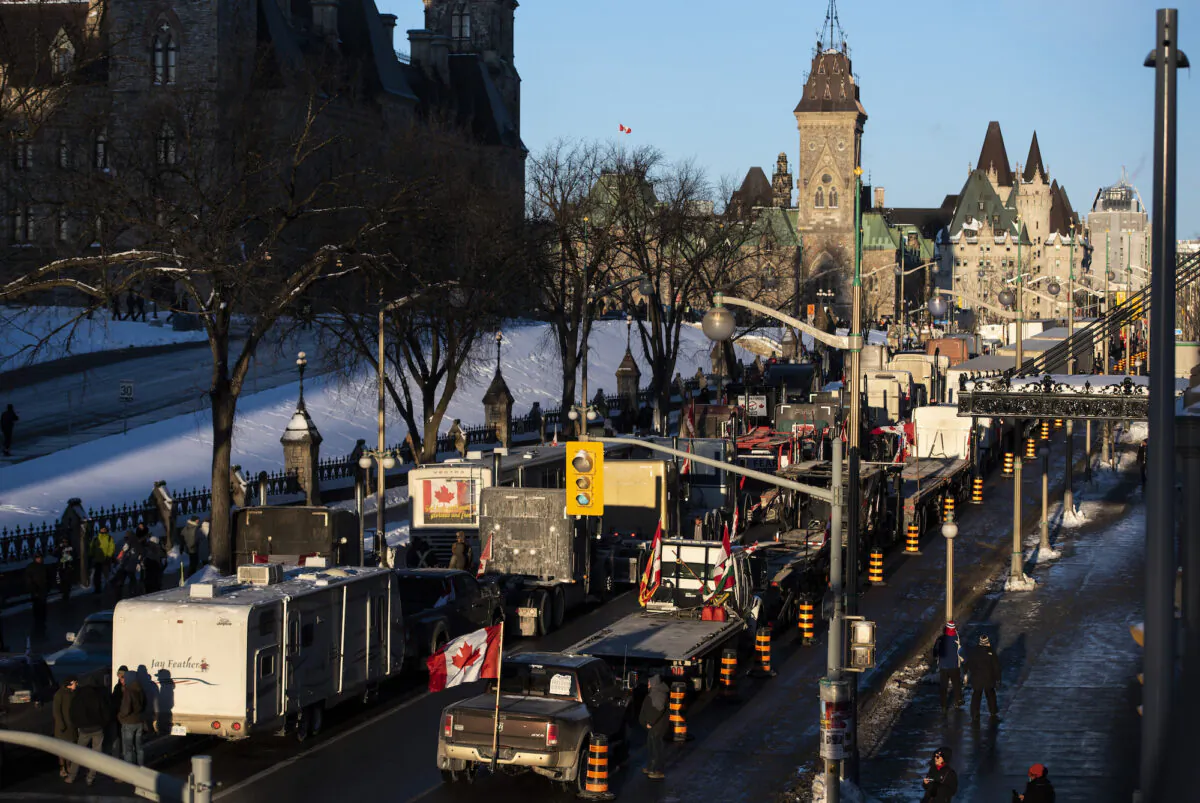 Trucks participating in a cross-country convoy protesting COVID-19 mandates and restrictions are parked on Wellington Street in front of Parliament Hill in Ottawa on Jan. 28, 2022. (The Canadian Press/Justin Tang)