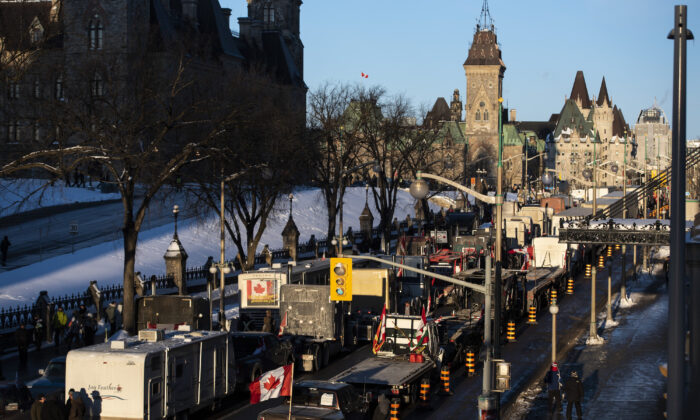 Trucks participating in a cross-country convoy protesting COVID-19 mandates and restrictions are parked on Wellington Street in front of Parliament Hill in Ottawa on Jan. 28, 2022. (The Canadian Press/Justin Tang)