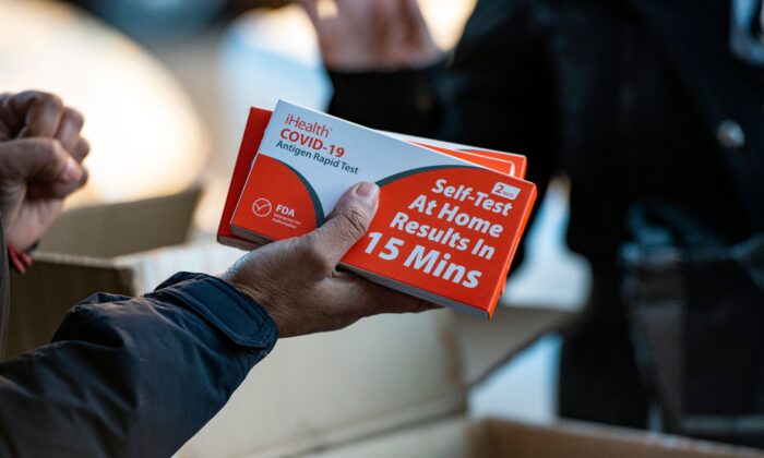 Rapid at-home COVID-19 test kits are distributed by the GreenRoots environmental protection organization and Chelsea Community Connections in Chelsea, Mass., on Dec. 17, 2021. (Joseph Prezioso/AFP via Getty Images)