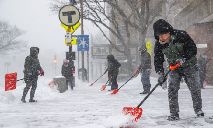 People shovel outside of the Davis Square MBTA station during a snowstorm in Somerville, Mass., on Jan. 29, 2022. (Adam Glanzman/Getty Images)