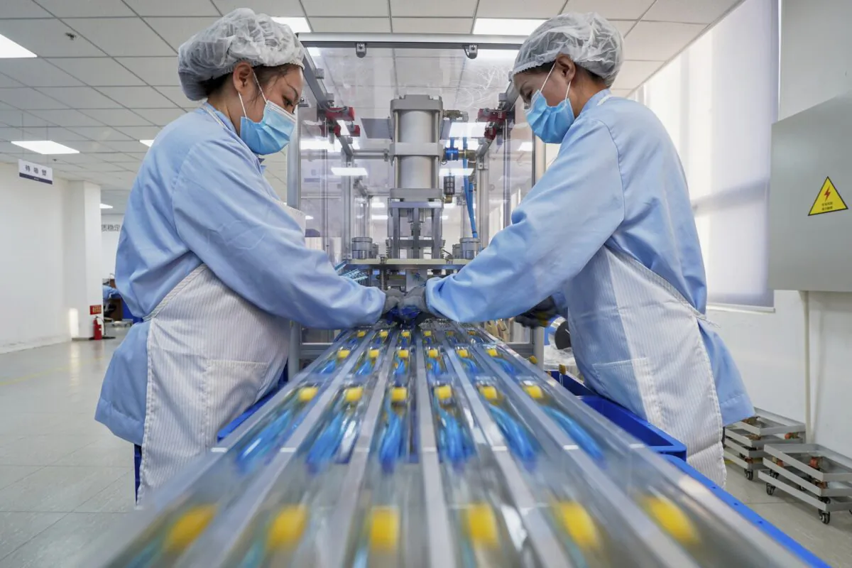 Workers wearing protective masks align the toothbrushes on the production line at a factory in Yantai, in east China's Shandong province, on Jan. 20, 2022. (Chinatopix via AP)