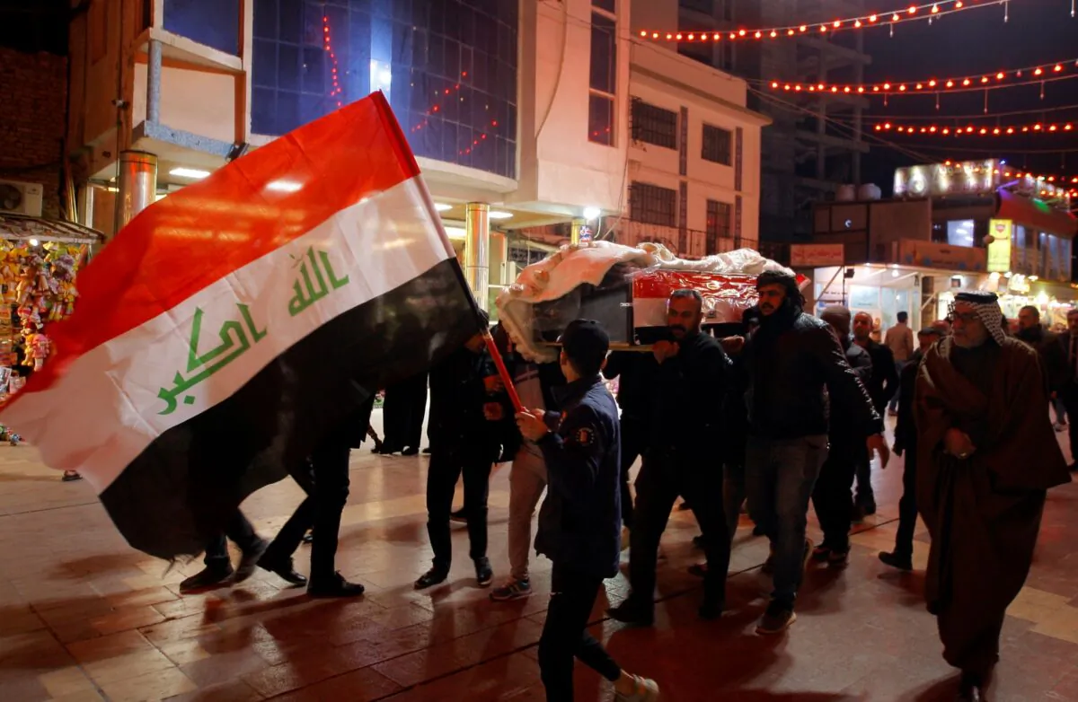 Mourners carry the flag-draped coffins of Iraqi soldiers killed in an attack by gunmen of the ISIS terrorist group in Baqouba in Diyala province during a mass funeral procession inside the shrine of Imam Ali in Najaf, Iraq, on Jan. 21, 2022. (Anmar Khalil/AP Photo)
