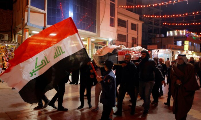 Mourners carry the flag-draped coffins of Iraqi soldiers killed in an attack by gunmen of the ISIS terrorist group in Baqouba in Diyala province during a mass funeral procession inside the shrine of Imam Ali in Najaf, Iraq, on Jan. 21, 2022. (Anmar Khalil/AP Photo)