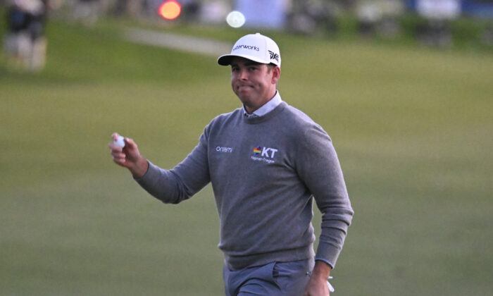 Luke List holds the ball up after hitting a birdie putt on the 18th hole of the South Course during the final round of the Farmers Insurance Open golf tournament in San Diego on Jan. 29, 2022. (Denis Poroy/AP Photo)