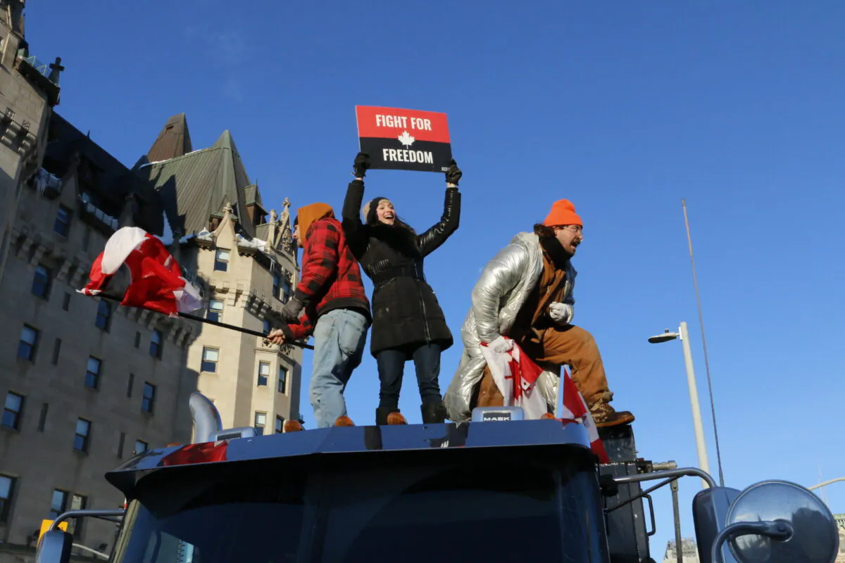 Protesters stand atop a truck in downtown Ottawa on Jan. 29, 2022, at the beginning of the Freedom Convoy demonstration. (Noé Chartier/The Epoch Times)