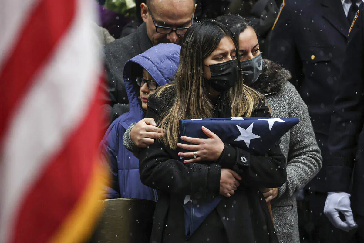 Dominique Rivera (L), wife of NYPD Officer Jason Rivera, watches as his casket is loaded into a hearse outside St. Patrick's Cathedral after his funeral service in New York on Jan. 28, 2022. (Yuki Iwamura/AP Photo)