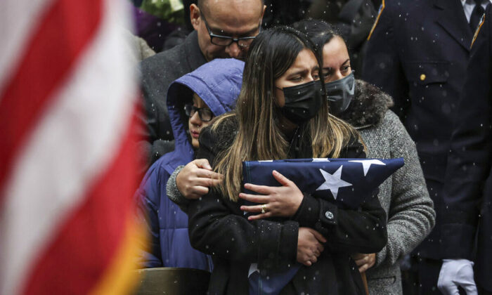 Dominique Rivera (L), wife of NYPD Officer Jason Rivera, watches as his casket is loaded into a hearse outside St. Patrick's Cathedral after his funeral service in New York on Jan. 28, 2022. (Yuki Iwamura/AP Photo)