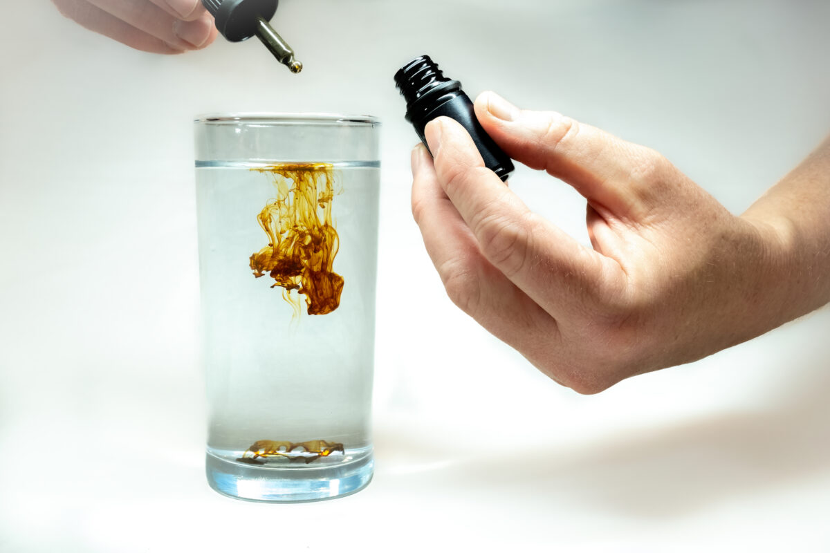 A single drop of concentrated Colloidal Silver being diluted in a glass of water. By samray/Shutterstock