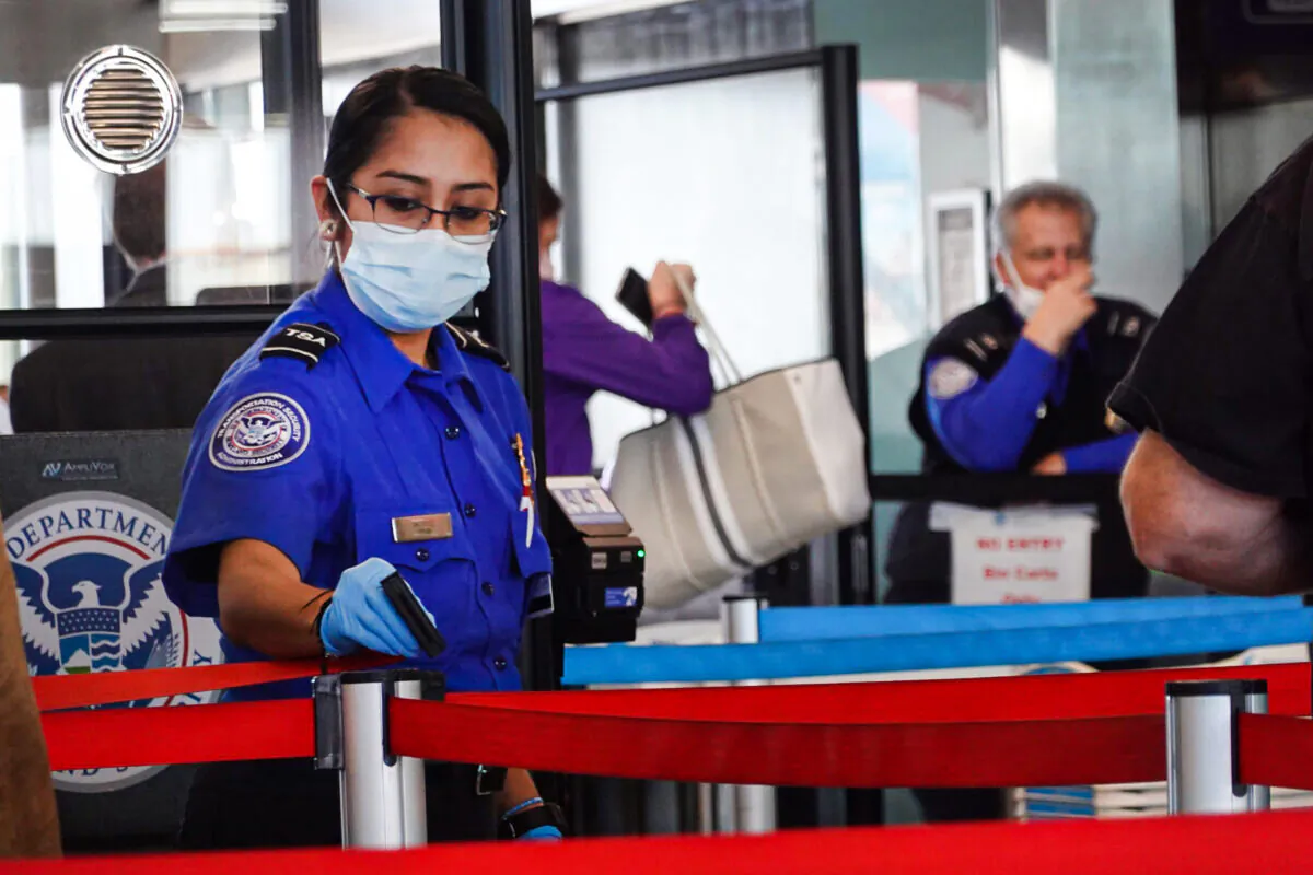 Transportation Security Administration (TSA) workers screen passengers at O'Hare International Airport in Chicago on Nov. 8, 2021. (Scott Olson/Getty Images)